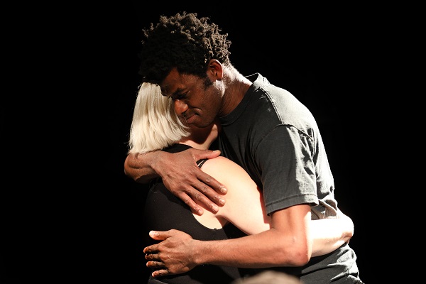 Two actors from White Pariahs: Quiet Rebels: a young man of African heritage embracing an older white woman.